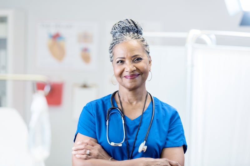 LGI Healthcare Solutions Santé female nurse in blue scrubs smiling